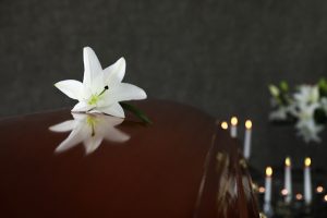 Wooden,Casket,With,White,Lily,In,Funeral,Home,,Closeup.,Space